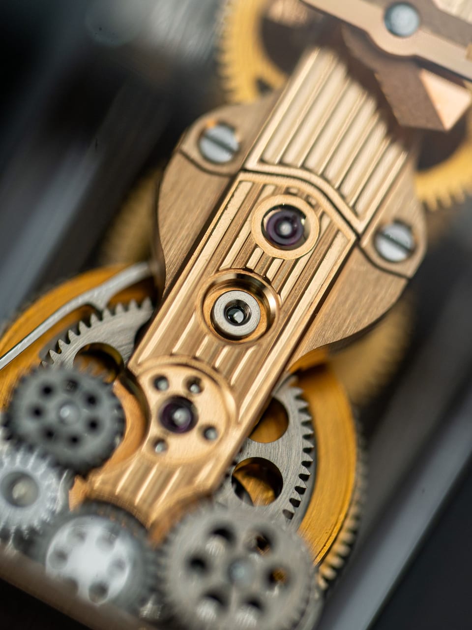 Macro shot of caliber X-14 bridges and gears: Geneva stripes, blued screws, brass plates